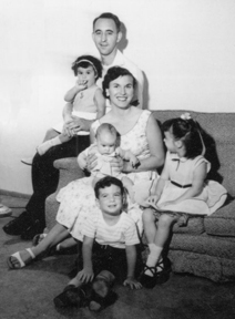 Black and white photo of a family posing on a sofa